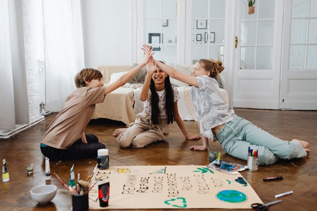 Three teenagers working on an eco-friendly project, high-fiving in a cozy indoor setting.
